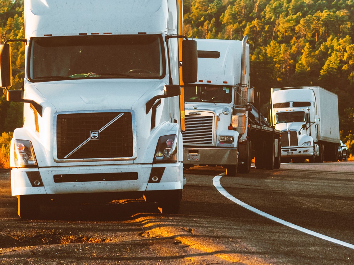 18 wheelers lined up on the side of a roadway
