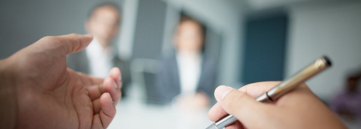 writing on document at meeting table