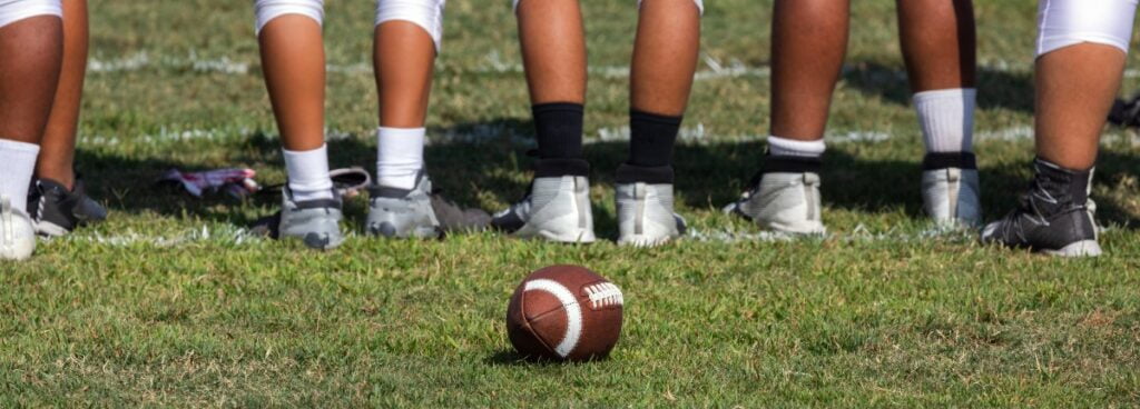 youth football players on field during daytime