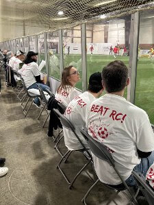 fans near glass of soccer field