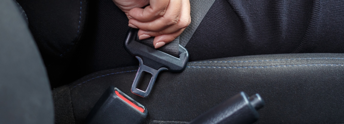 An individual putting on a seat belt